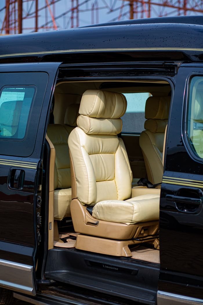 Luxurious cream leather seats inside a black van with an open door.